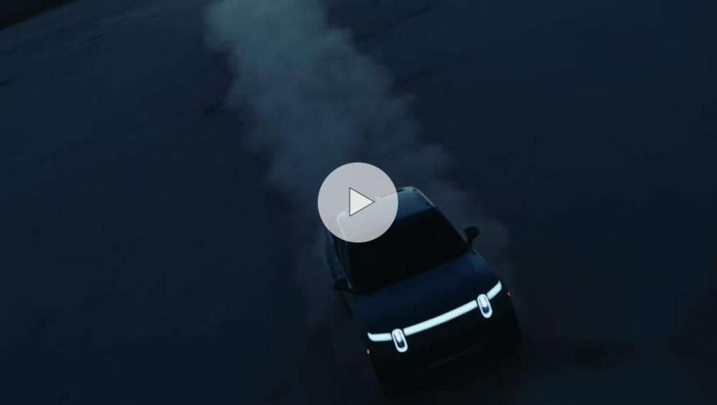 A car kicks up dust driving across a plain far away from a downtown city area